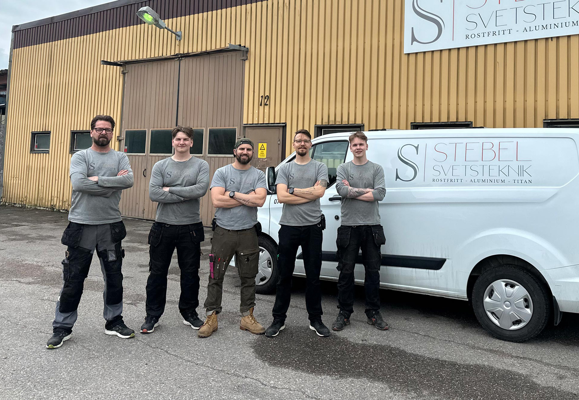 Teamet på Stebel Svetsteknik framför en företagsbil och deras gula byggnad